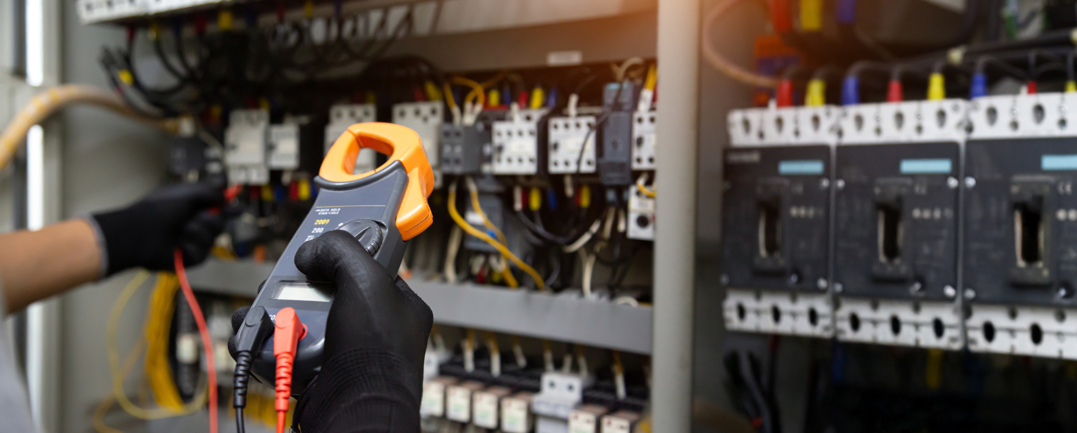 Electrical technician hand checking electricity circuit breaker main power on switchboard cabinet for service maintenance and electric cable wiring check
